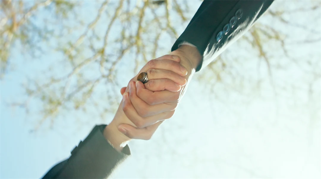 Två händer som håller i varandra utomhus