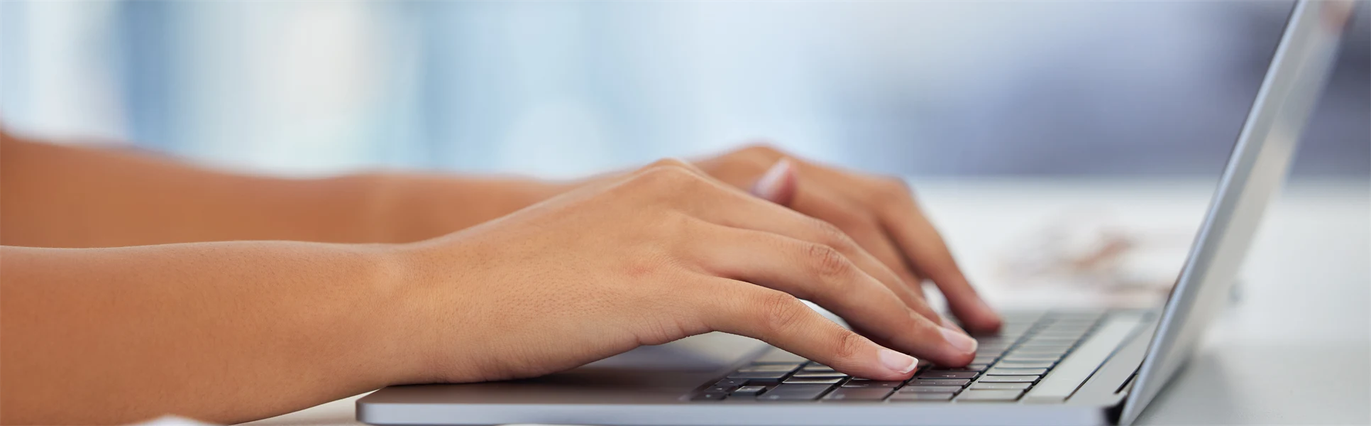 Två händer om skriver på en laptop