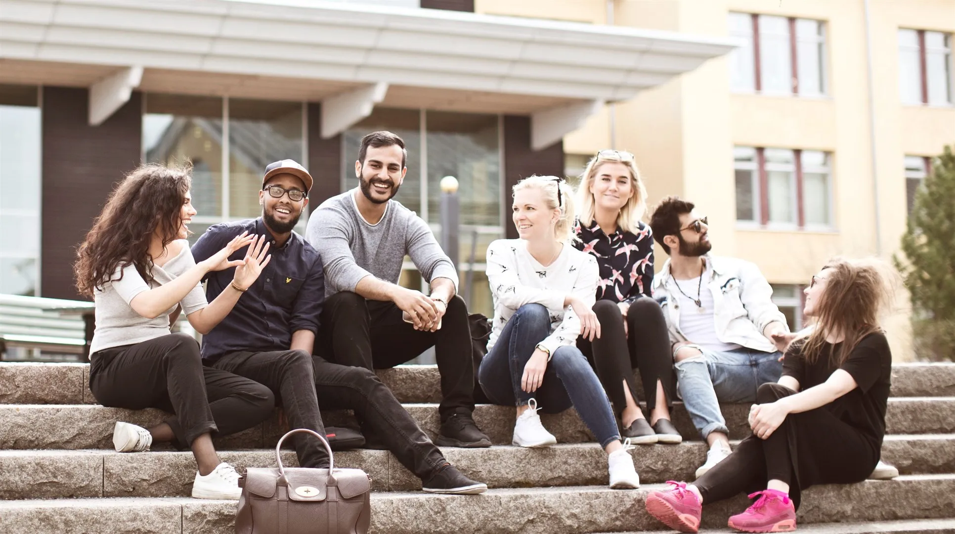 En grupp studenter sitter på en stentrappa, campus Östersund