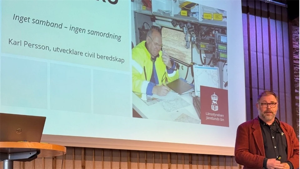 En man som står framför en stor projektorduk och föreläser