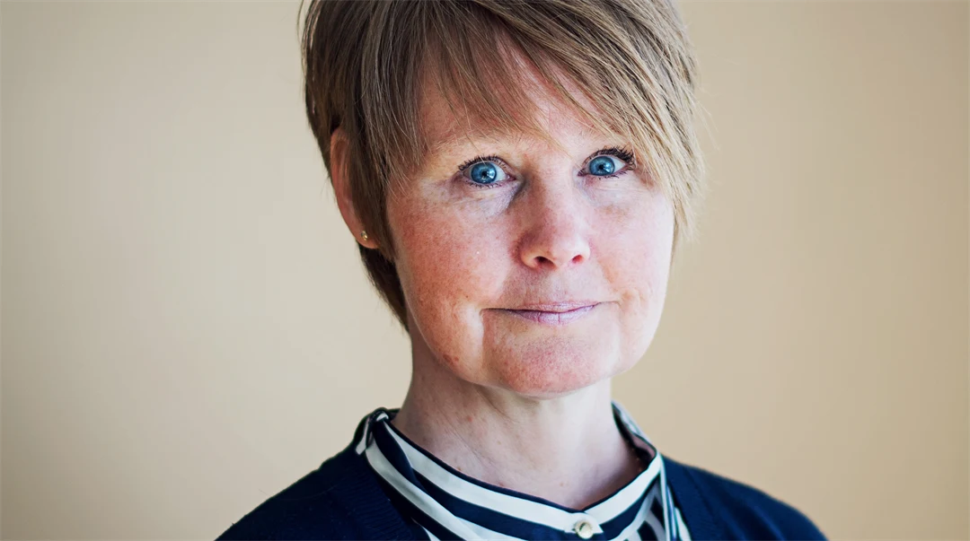 Kvinna i blåvitrandig blus och blå kofta