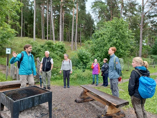Människor i grupp vid grillplats.