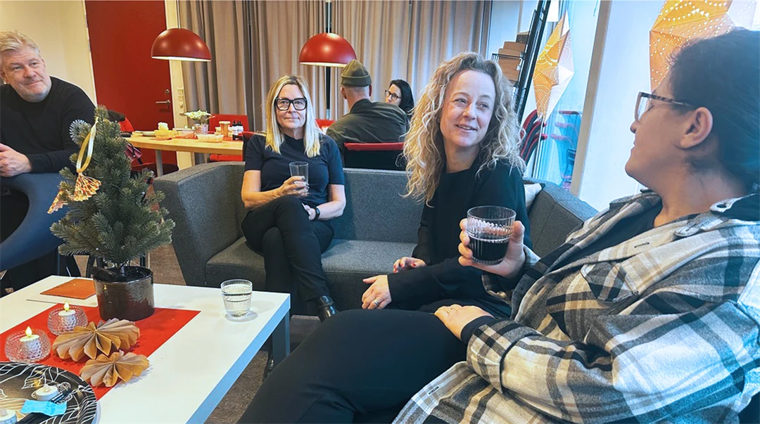 folk som sitter i en soffa och dricker kaffe