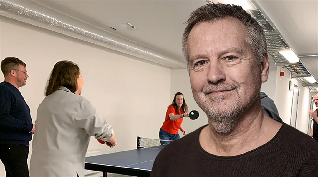 folk spelar pingis i bakgrunden, i förgrunden en man som ler