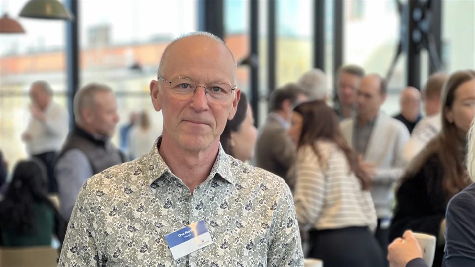 En man med glasögon tittar in i kameran. 