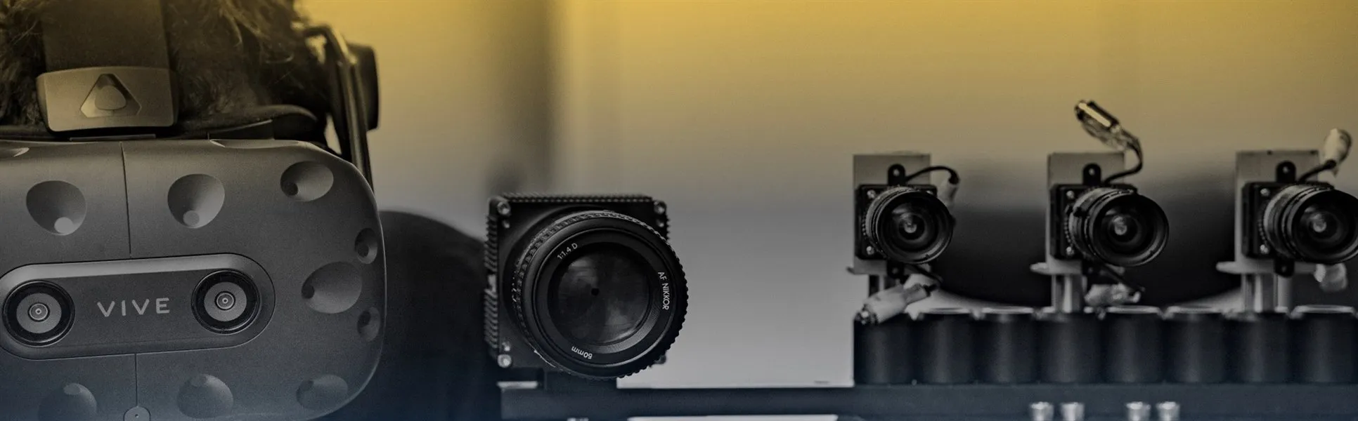 A man with a VR headset on standing next to a set up of smaller cameras.