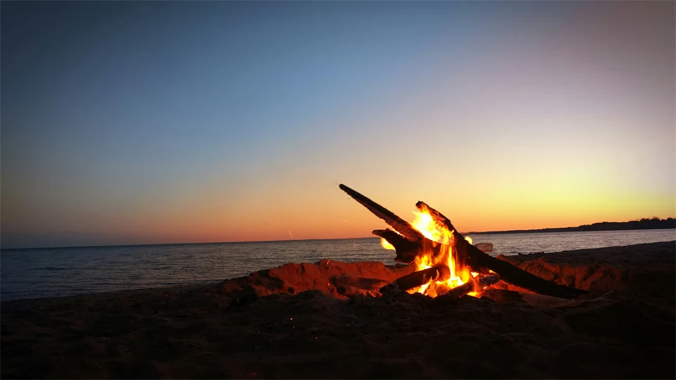 En lägereld utomhus framför havet 