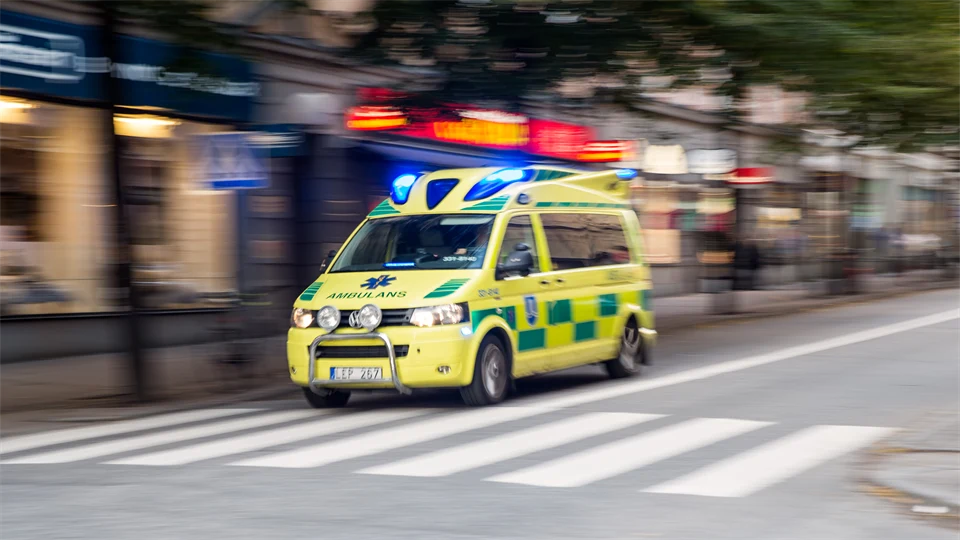 Stor ambulans under utryckning i stadsmiljö.
