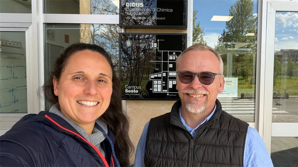 En kvinna och en man med solglasögon ler och tittar in i kameran.