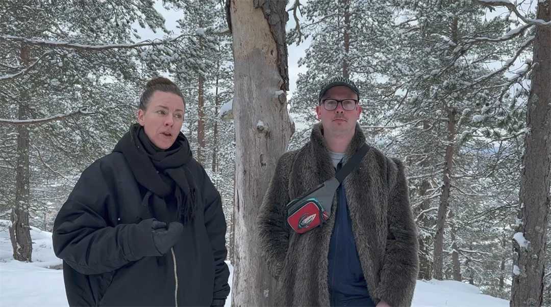 En blond kvinna med svart jacka och en man med keps och grå jacka