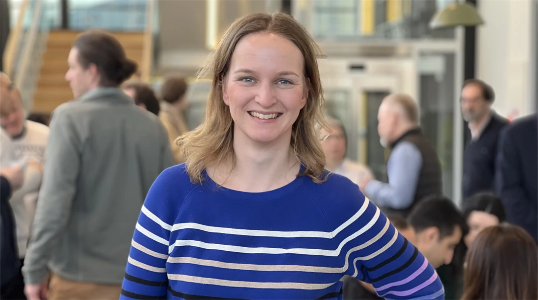 En kvinna som ler tittar in i kameran.