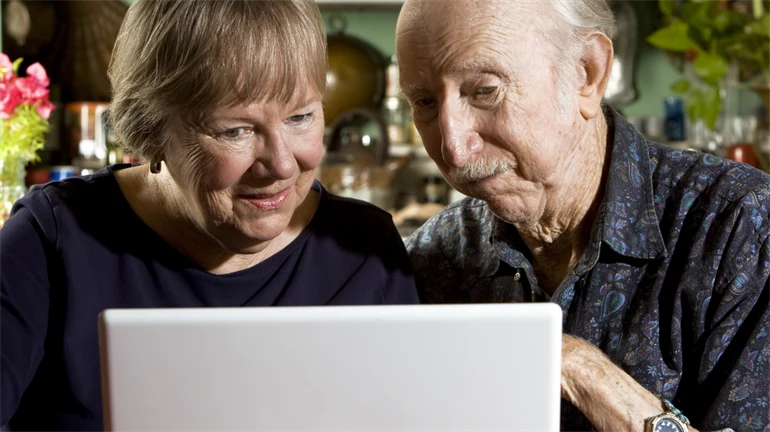 Pensionärer framför dator