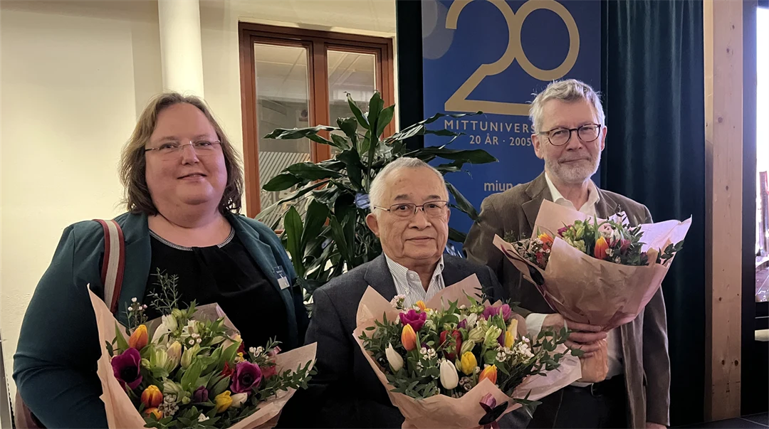  Three people each with a large bouquet of flowers stand next to each other.