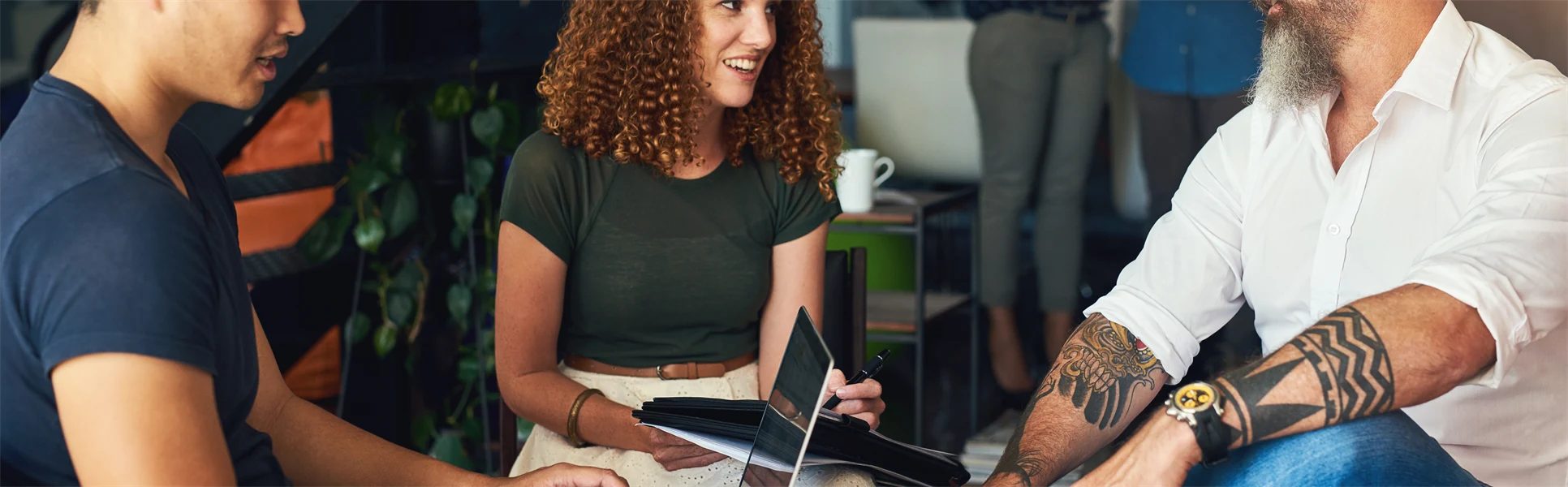 Tre människor som sitter och pratar med varandra.