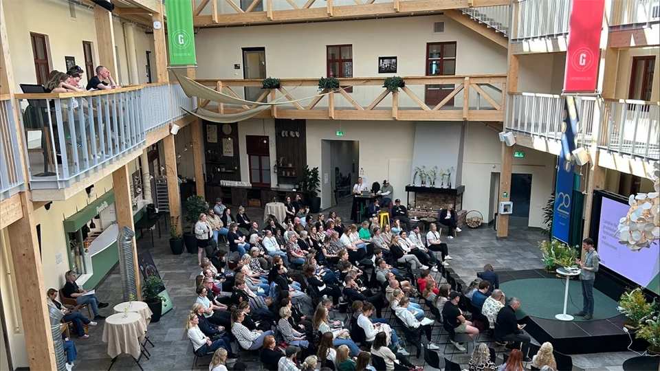 Foto ovanifrån på flera människor som sitter på stolar framför en scen