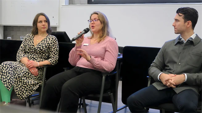 Tre alumner sitter i stolar längst fram i salen och samtalar