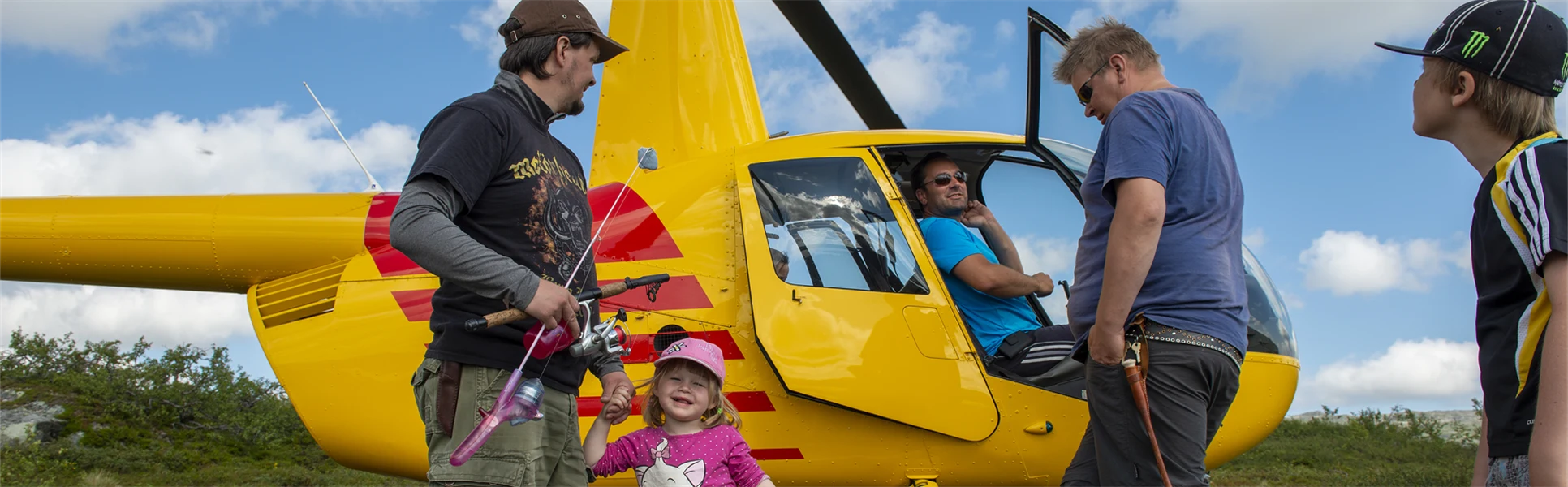 Två män och två barn intill en gul helikopter.
