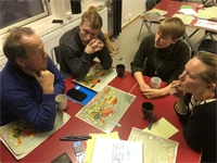 Fyra personer diskuterar kartor.