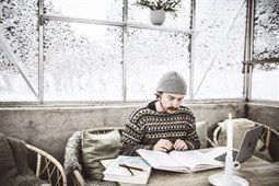 Läser sittande i soffa