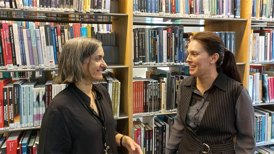 Teresa Silva och Laryssa Bielik pratar framför en bokhylla