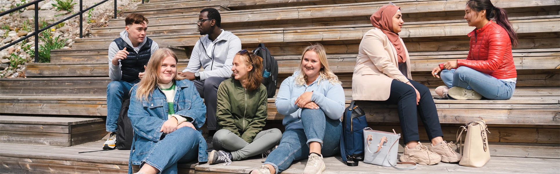 Sju studenter som sitter i en trappa.