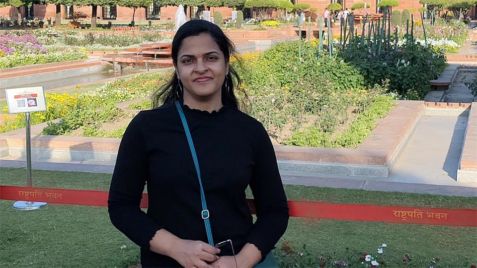 en kvinna står framför en trädgård