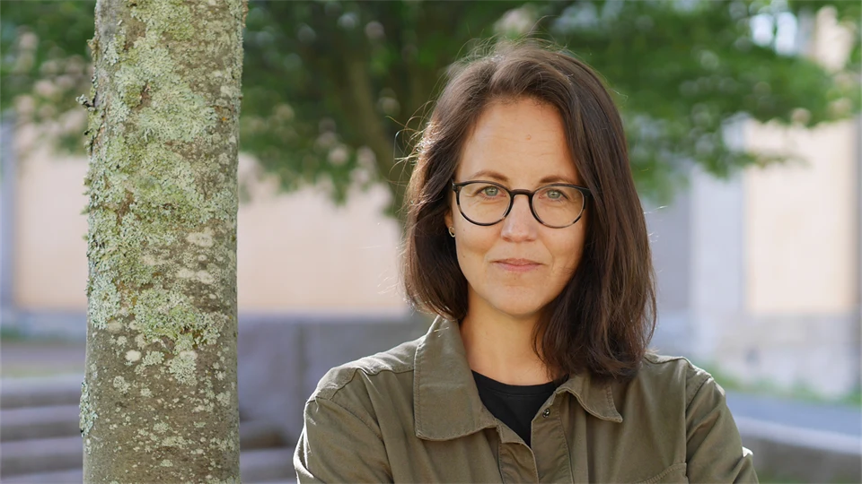 Kvinna med brunt hår och glasögon