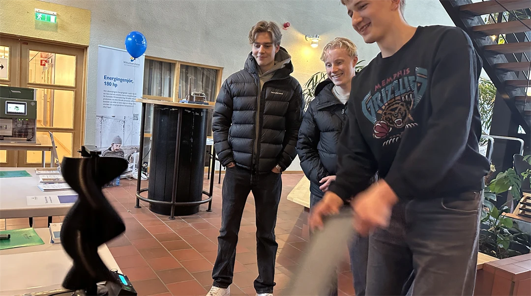 Tre män tittar på ett bord.