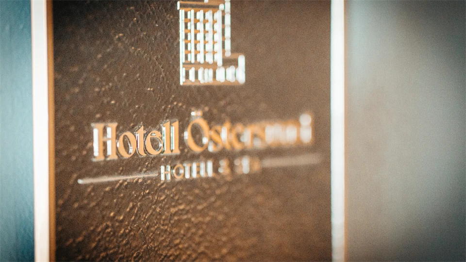 Ett något abstrakt fotografi på en skyl med texten Hotell Östersund