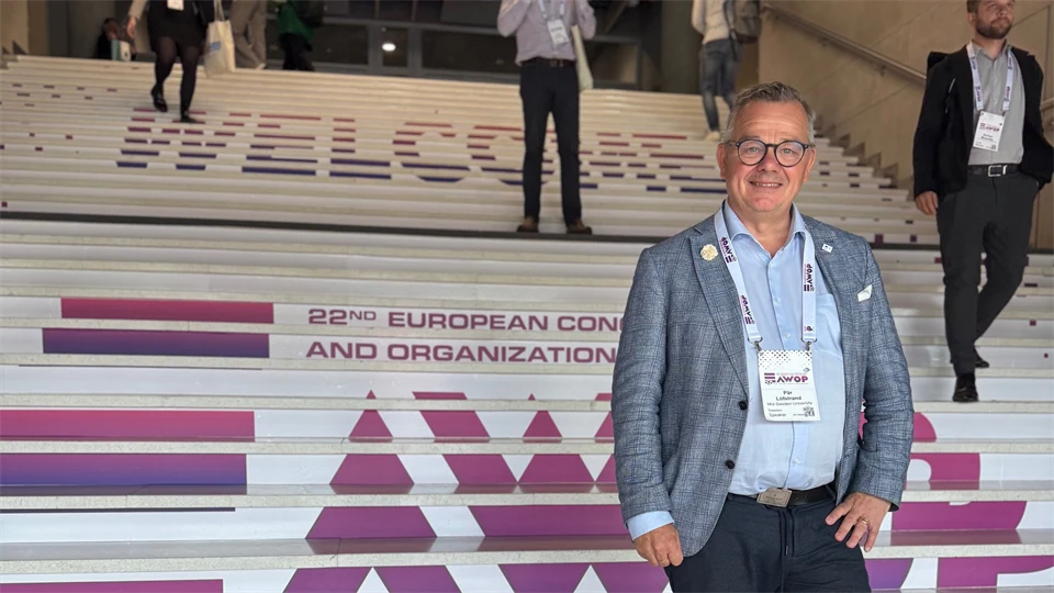 Man in a jacket standing on stairs.