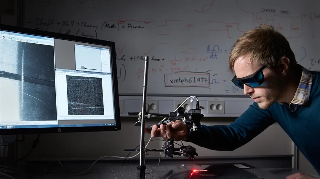 Researcher using instruments in a lab to characterize a surface.