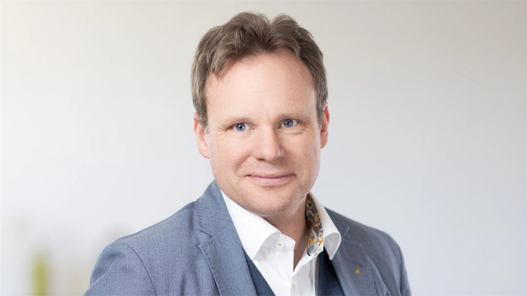 Porträttbild på en man i blå kavaj.