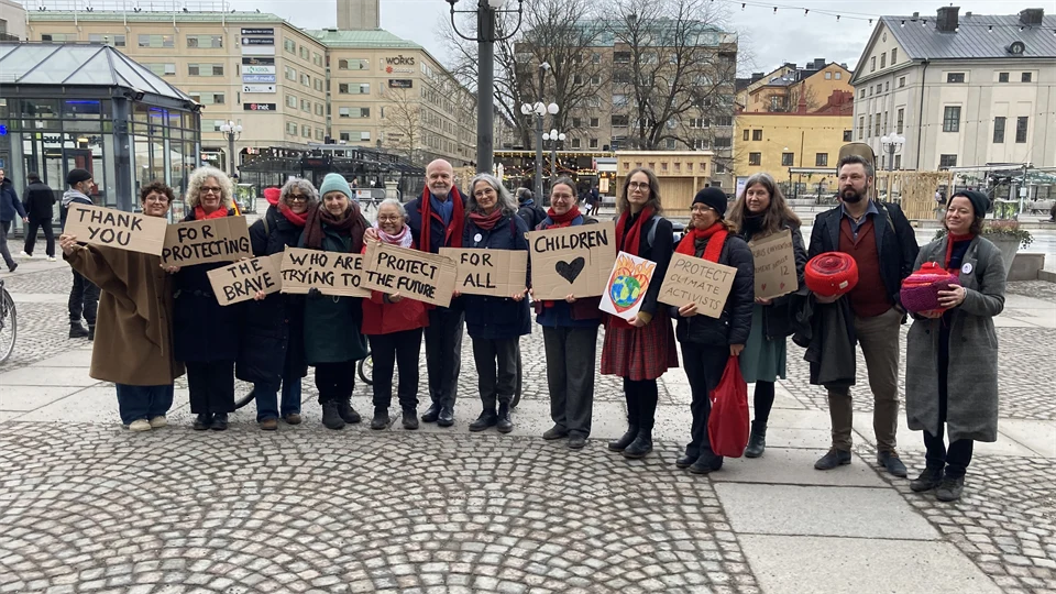 Grupp på torg som håller skyltar med budskap