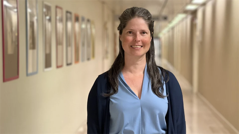 A woman is standing in a corridor.