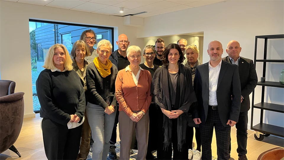 En grupp människor står framför ett fönster.