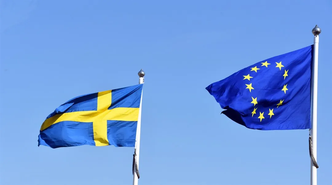Svenska flaggan och EU flaggan mot blå himmel