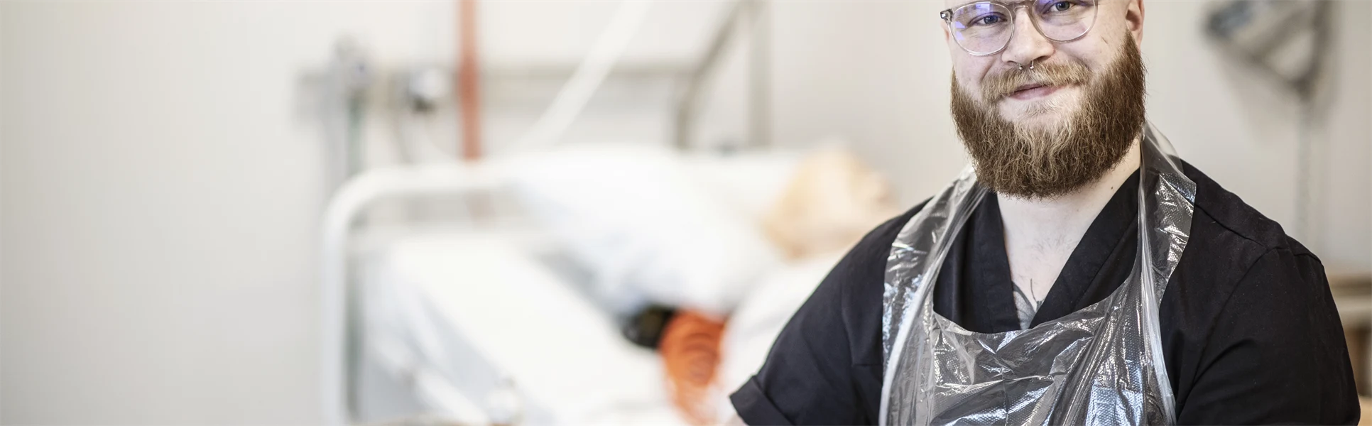 En man med skägg är i en sjukhusmiljö.