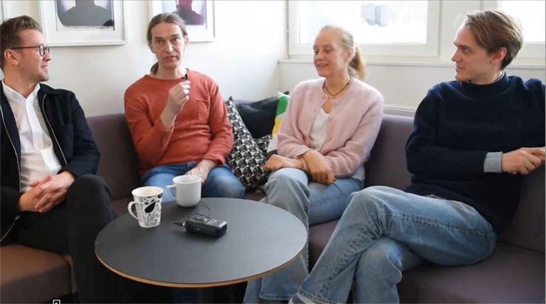 Fyra personer sitter i en soffa och pratar