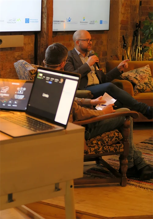 Två talare sitter i soffa på scenen och pratar i mikronfoner, under Möteslänken 2026