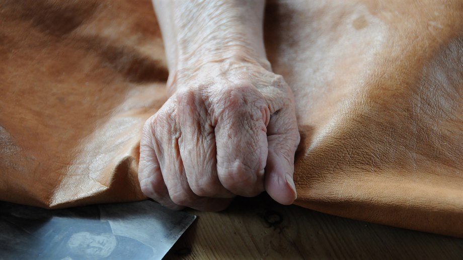 Martha Elise Jåma arbetar med ett stycke garvat renskinn