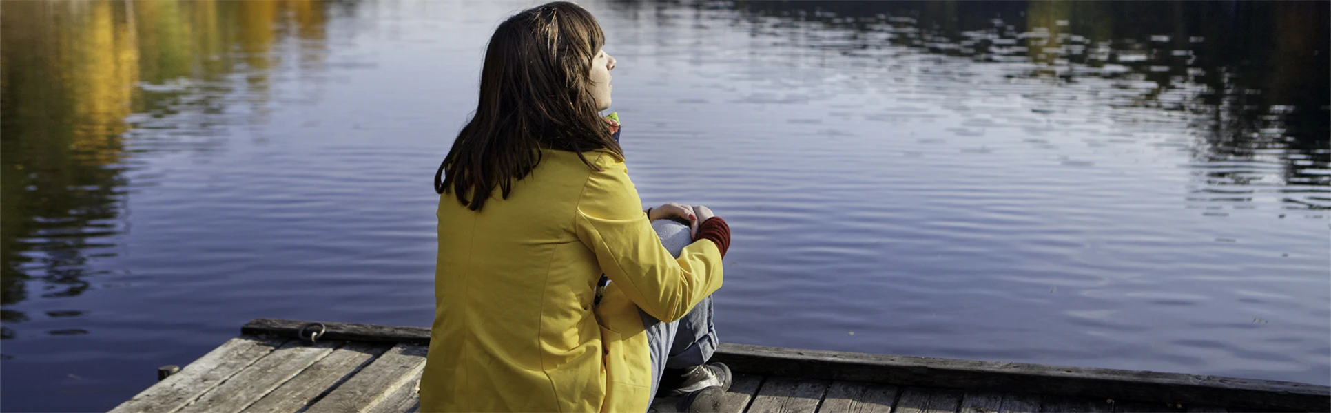 naturturist - en kvinna som sitter på en brygga.