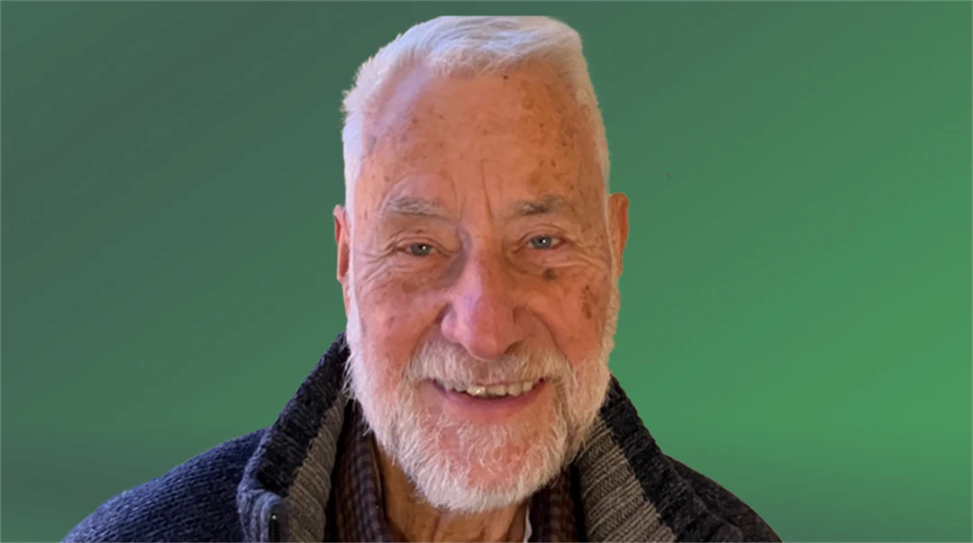  A man smiles and looks into the camera.