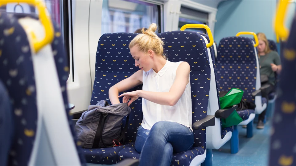 kvinna som åker tåg letar i sin väska