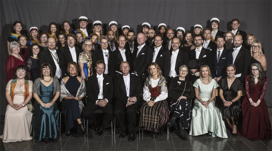 A group photo of just over fifty well-dressed people.
