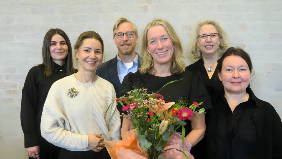 En grupp med sex forskare står framför en vägg i en lärosal