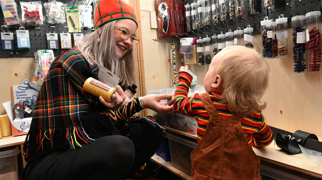 En kvinna och ett litet barn ser på slöjdmaterial i en butik