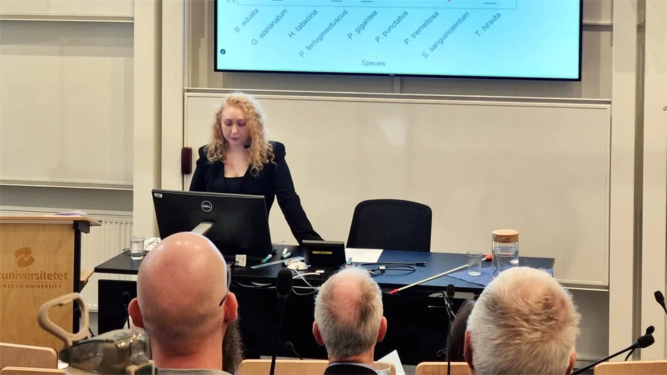 en kvinna står i en lärosal framför en publik