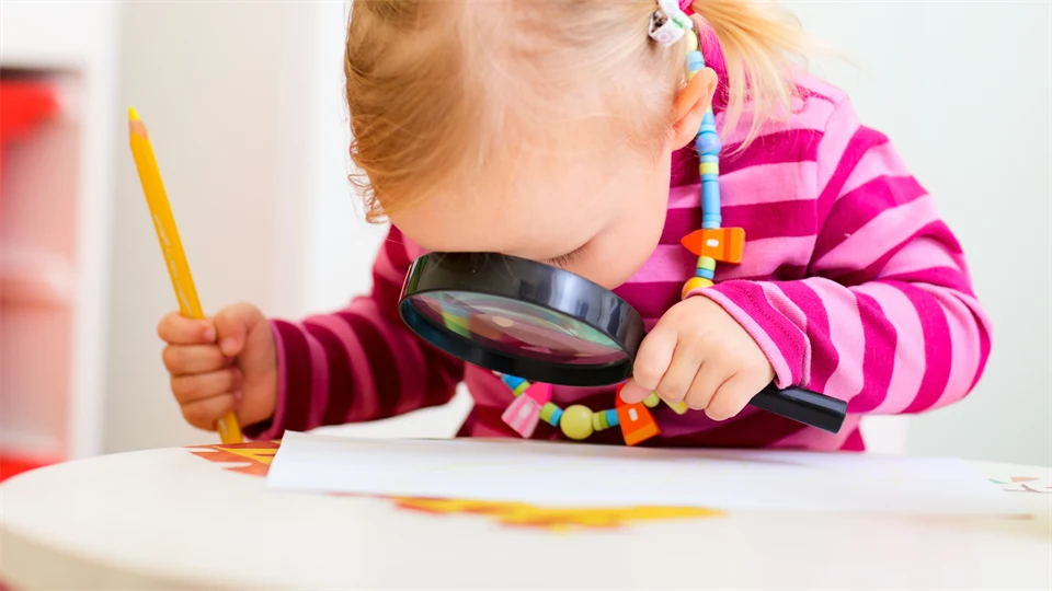 Förskolebarn tittar i förstoringsglas