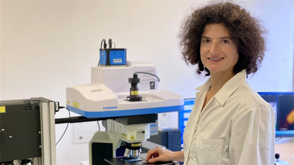  A woman in a laboratory setting smiles and looks into the camera.