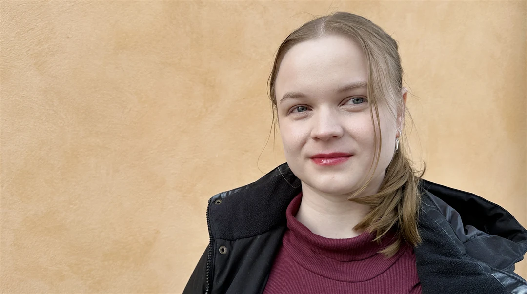 Ung tjej står framför en gul vägg